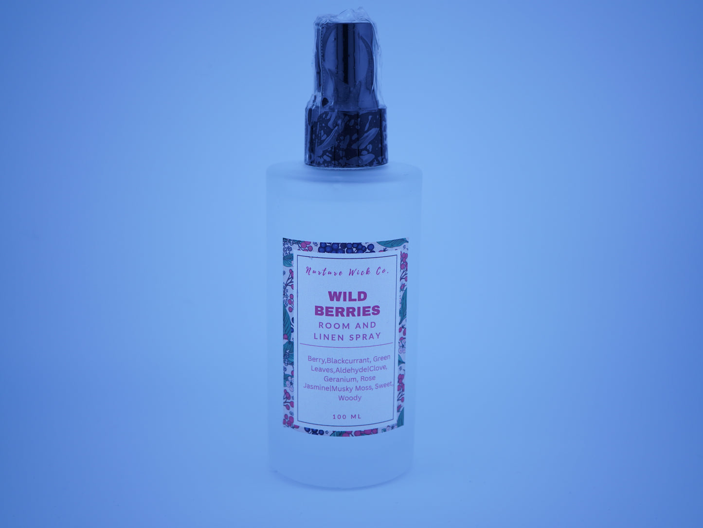 Bottle of 'Wild Berries' room and linen spray with a blue tint.