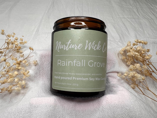 Candle with 'Nurture Wick' label on a textured surface with dried flowers