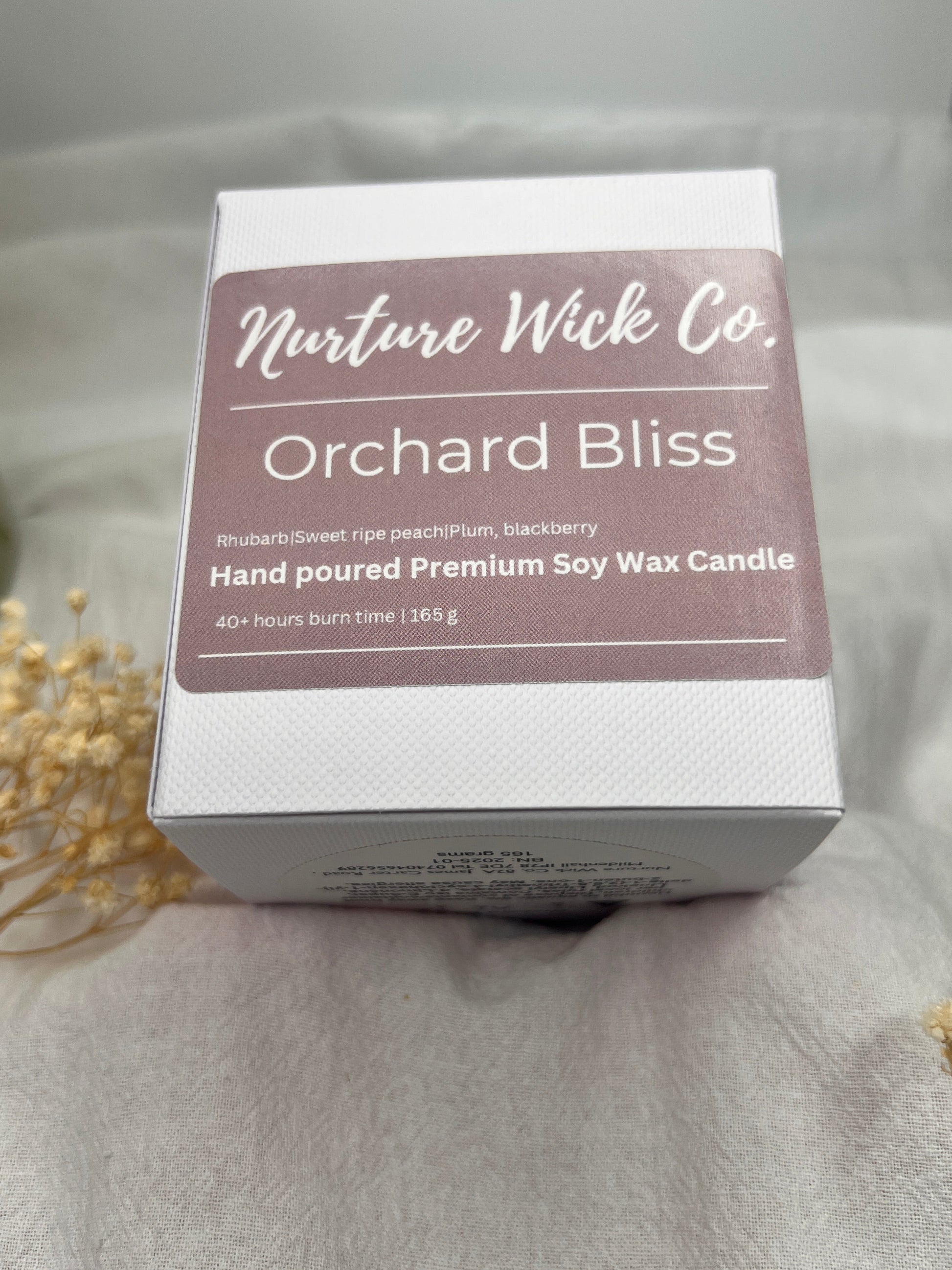 Box of Orchard Bliss candle from Moisture Wash Co. on a soft gray background