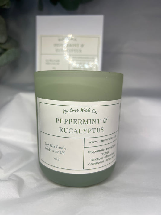 Green candle with a label on a white surface
