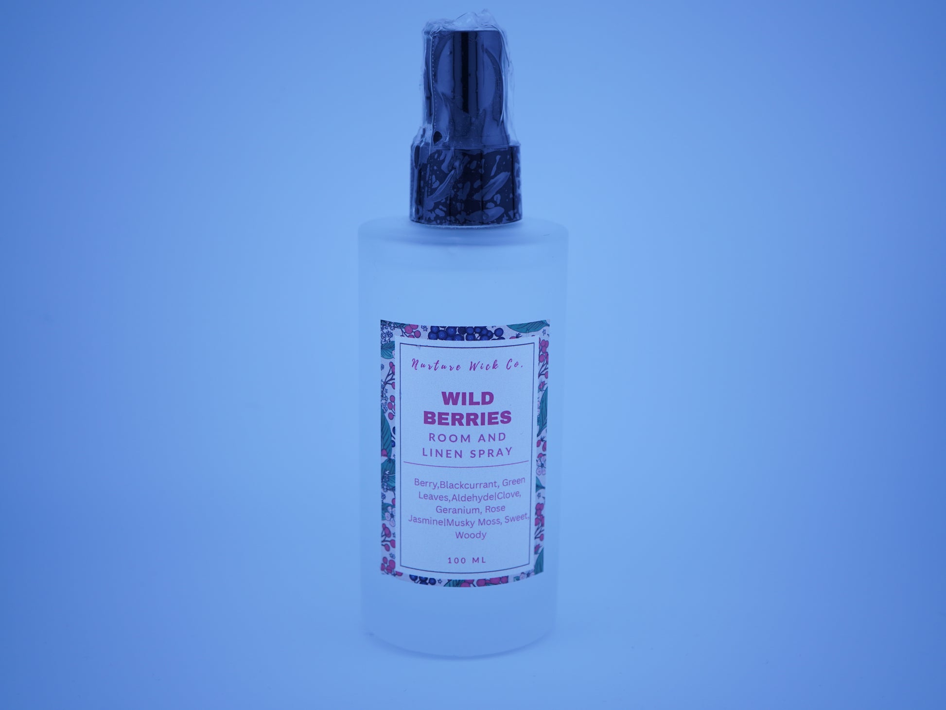 Bottle of 'Wild Berries' room and linen spray with a blue tint.